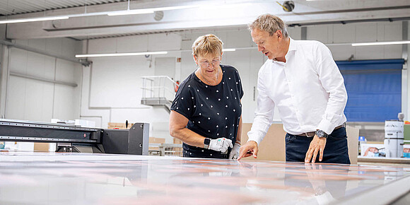 Zwei Mitarbeiter in der Produktion vor einem Tisch mit Mustern