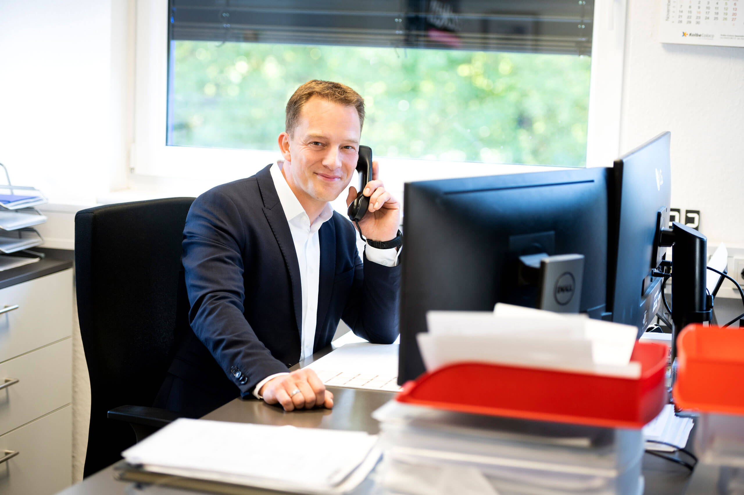 Creodis Mitarbeiter telefoniert und sitzt am Schreibtisch